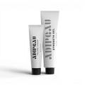 Two tubes of Adipeau hair care products on a white background